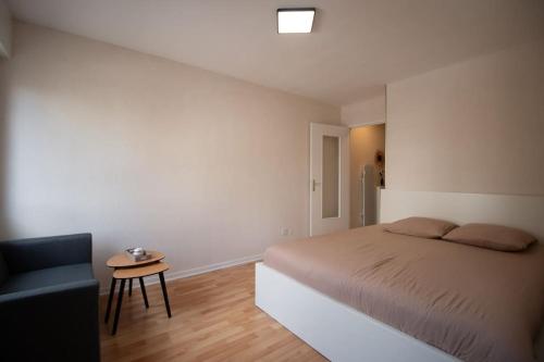 une chambre avec un lit, une chaise et une table dans l'établissement Studio Strasbourg proche gare, à Strasbourg