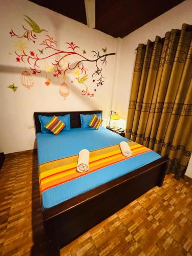 a bedroom with a bed with a painting on the wall at CITYSCAPE YALA BY 999 HOTEL & RESTAURANT in Tissamaharama