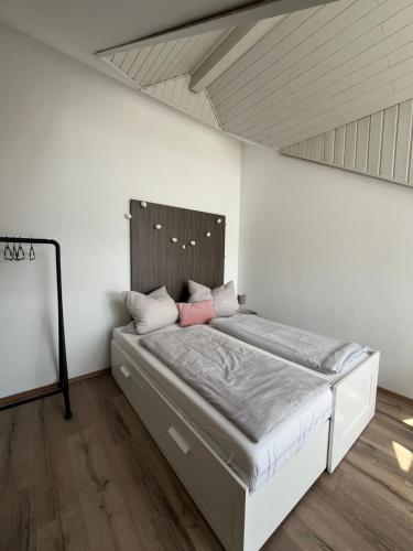 a bed in a room with a white wall at Moderne Wohnung mit Dachterrasse in Groß-Umstadt