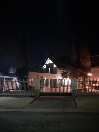a fence in front of a white house at night at De La Grace in Potchefstroom