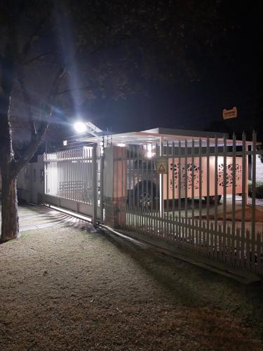 a bus is parked behind a fence at night at De La Grace in Potchefstroom