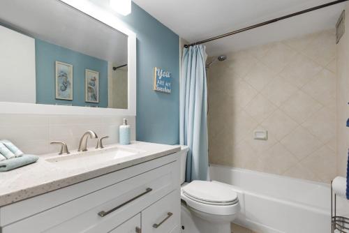 um banheiro com uma pia, um vaso sanitário e um espelho em MV2104 Welcoming Tropical Get-Away at the Pool em Kihei