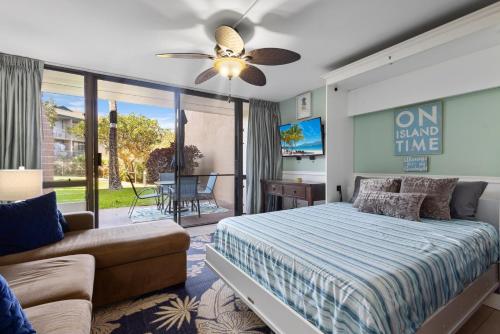 um quarto com uma cama e um sofá em MV2104 Welcoming Tropical Get-Away at the Pool em Kihei
