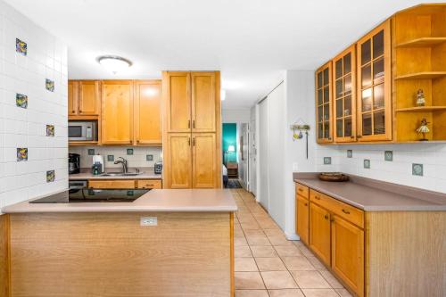 a kitchen with wooden cabinets and a counter top at MV3220 Modern Beautiful Tropical Gardenview in Kihei