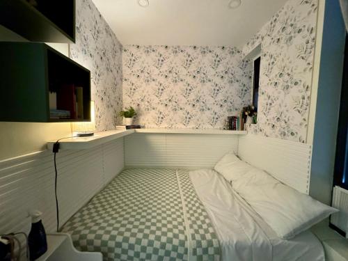 a small room with a bed with a checkered floor at Columbus House in New York