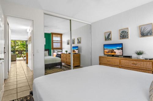 a bedroom with a bed and a television in a room at MV3220 Modern Beautiful Tropical Gardenview in Kihei