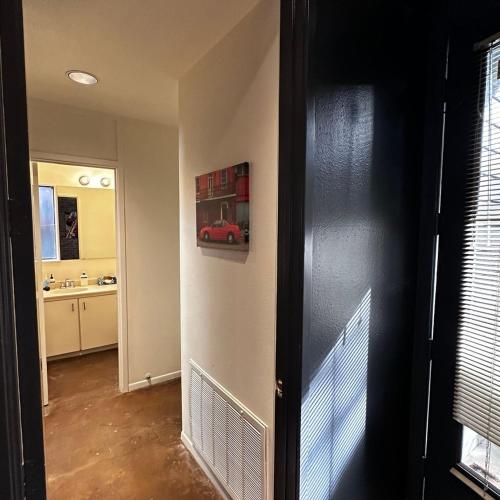 a hallway with a door to a kitchen with a car on the wall at Chic In The City in Houston