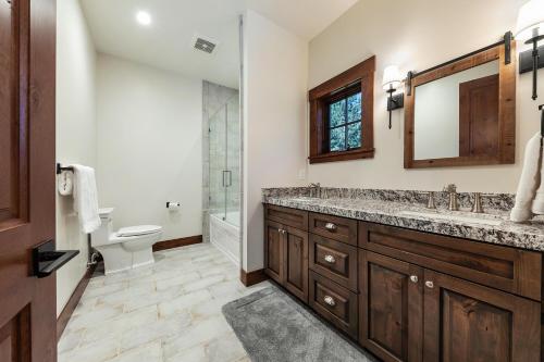 a bathroom with a sink and a toilet and a mirror at Arcadia Manor on the West Shore - Newly Built - 5 BR w Wet Bar EV Charger and Air Conditioning in Tahoe City