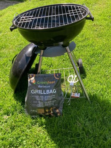 a grill with a bag of chips next to it at Hooiberghut op boerderij in Leidschendam