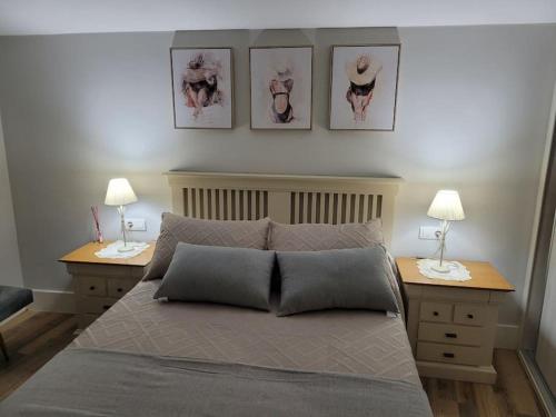 a bedroom with a bed with two night stands and two lamps at Casa Mateo in Allariz