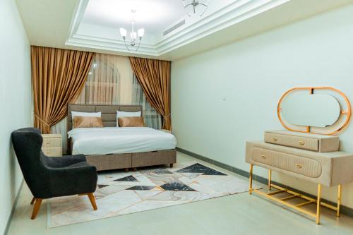 a bedroom with a bed and a mirror and a chair at Niamey Mall & Residence in Niamey