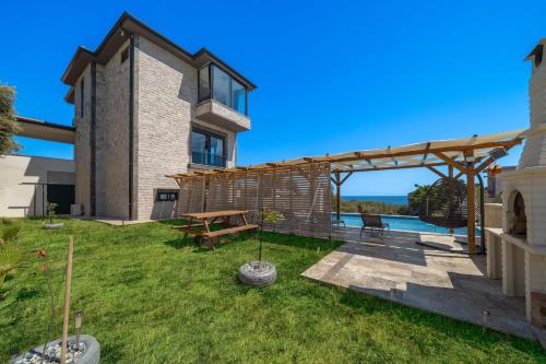 a backyard with a picnic table and a wooden pergola at Villa Bella in Kum