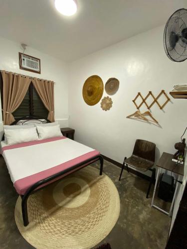 a bedroom with a bed and a table and a chair at Hiraya Homestay Coron in Coron