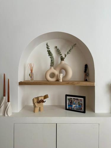 une étagère avec deux vases et une photo sur celle-ci dans l'établissement Paris Marais 8RDL Home - 2 rooms, 2 bathrooms, terrace, à Paris