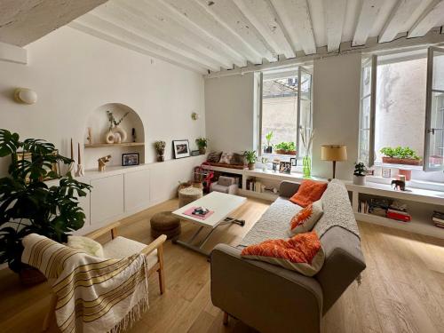un salon avec un canapé et une table dans l'établissement Paris Marais 8RDL Home - 2 rooms, 2 bathrooms, terrace, à Paris
