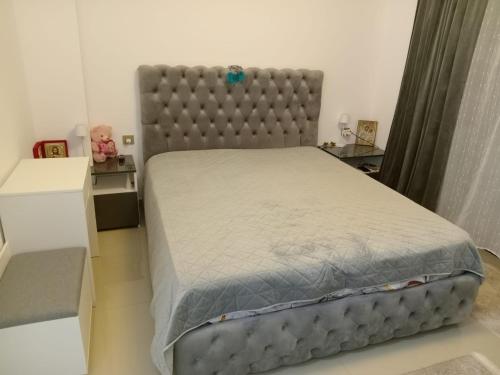 a bedroom with a large bed with a padded headboard at Perla Marii Penthouse in Eforie Nord