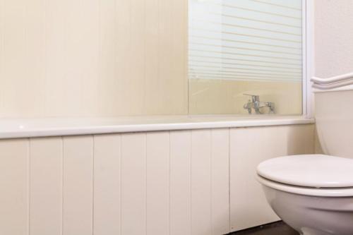 La salle de bains blanche est pourvue de toilettes et d'une baignoire. dans l'établissement Résidence Etoile - Studio pour 2 Personnes 284, à La Plagne Tarentaise