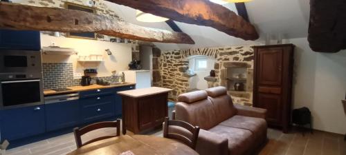 - une cuisine avec un canapé et une table dans une chambre dans l'établissement La Laiterie, à Saint-Beauzély