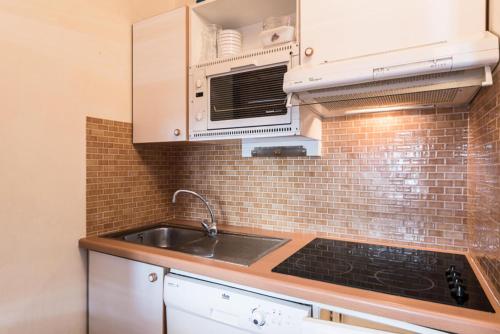une cuisine avec un évier et un micro-ondes dans l'établissement Résidence Prariond A - Studio pour 4 personnes au Val Claret MAE-7674, à Tignes