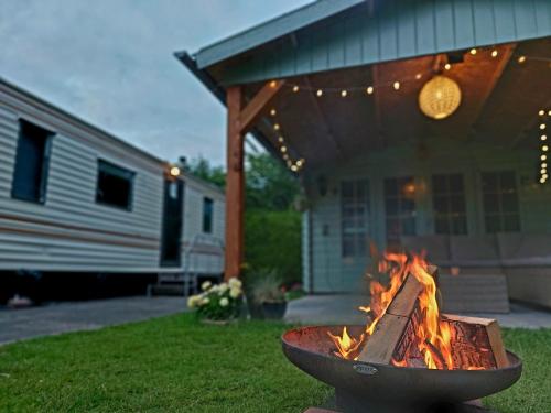 a fire pit in a yard in front of a house at Familychalet De Schaapskooi, 6-persons, big private garden, dogs aloud in Westergeest
