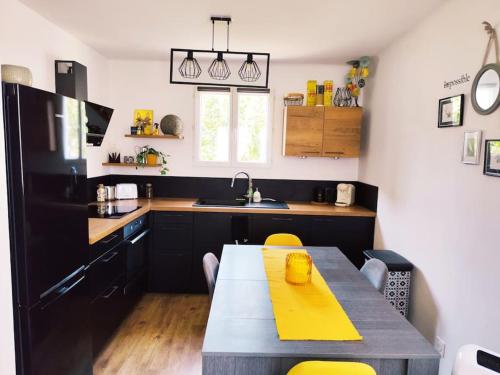 une cuisine avec une table et des chaises jaunes dans l'établissement Appartement au coeur de Céreste-en-Luberon, à Céreste
