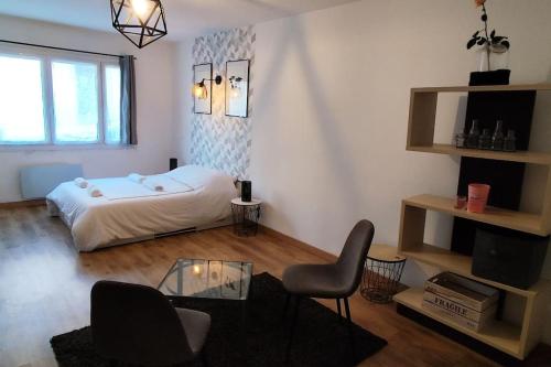 un salon avec un lit et une table en verre dans l'établissement Appartement au coeur de Céreste-en-Luberon, à Céreste