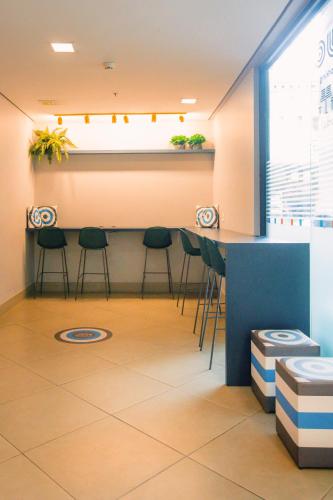 a room with a bar with stools and a counter at ibis budget BH Afonso Pena Savassi in Belo Horizonte