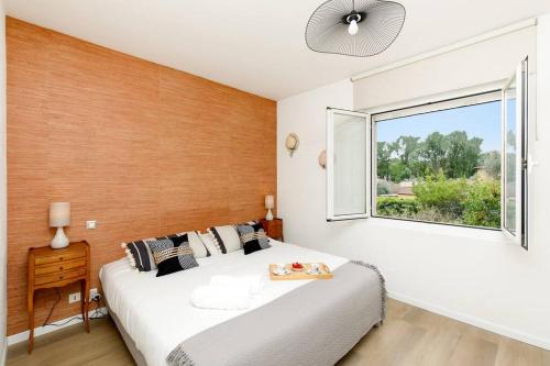 une chambre avec un grand lit blanc et une fenêtre dans l'établissement Welcome to Villa Gerlou, à Roquefort-les-Pins