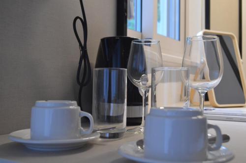 a table with glasses and cups and plates on it at LEONDIANA Boutique Hotel in Larnaca