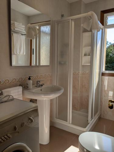 a white bathroom with a shower and a sink at Playa de Miño in Miño