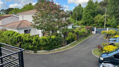 a driveway in front of a house with a tree at Appartement Alouette France in Pessac