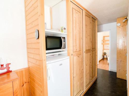 une cuisine avec un réfrigérateur et un micro-ondes dans l'établissement Résidence Prariond B - 2 pièces accès direct sur les pistes MAE-2584, à Tignes