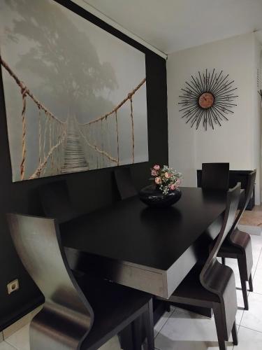 a dining room with a black table and chairs at Afrodite Apartment in Chrysoupolis