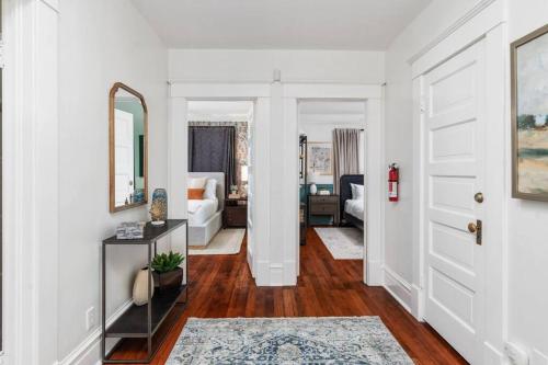 a hallway with white walls and a door with a mirror at Luxe Retreat Designed For Group Getaways in Lodi