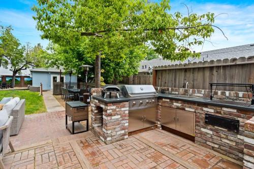 a backyard patio with a grill and an outdoor kitchen at Luxe Retreat Designed For Group Getaways in Lodi