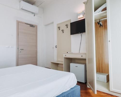 a white bedroom with a bed and a desk at Hotel all'Oasi in Paese