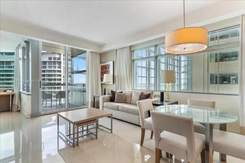 a living room with a table and a couch at Lux Aka Brickell Condo in Miami