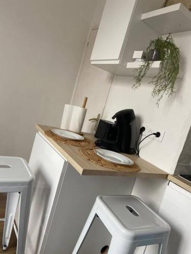 une cuisine avec un comptoir, un évier et deux tabourets dans l'établissement Le Bohème studio central, au Mans