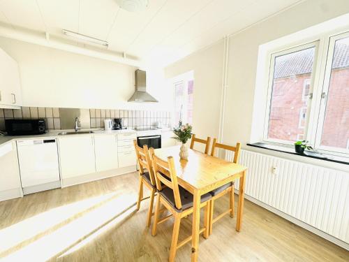 a kitchen and dining room with a wooden table and chairs at aday - Solsortvej Suite 2 Randers in Randers