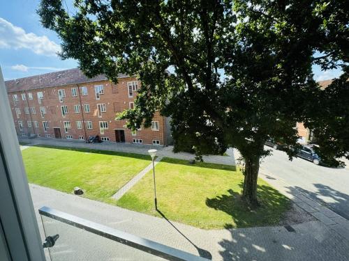 a view from a window of a building with a tree at aday - Solsortvej Suite 2 Randers in Randers