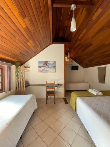 a room with two beds and a table at Pousada Ilha da Magia in Florianópolis
