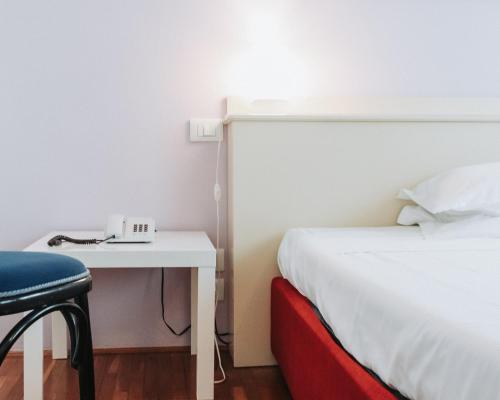 a hotel room with a bed and a desk with a phone at Hotel all'Oasi in Paese