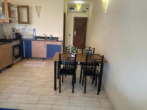 a kitchen with a table and chairs in a room at Seabreeze Haven in Diani Beach
