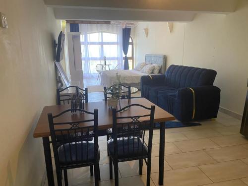 a living room with a table and chairs and a couch at Seabreeze Haven in Diani Beach