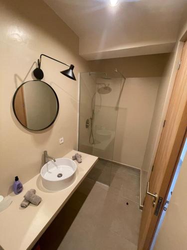 a bathroom with a sink and a mirror and a shower at Lagoon Apartment mit Pool Boa Vista in Sal Rei