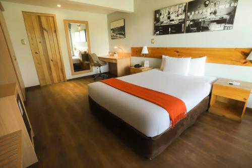 a hotel room with a large bed and a desk at Casa Andina Standard Chincha in Chincha Alta
