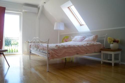 a bedroom with a bed with pink sheets and a window at Willa pod Lipami in Bartoszyce