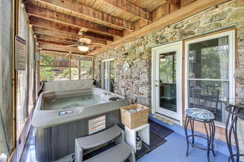 a jacuzzi tub in a room with a stone wall at Hot Springs Retreat with Private Dock and Hot Tub! in Hot Springs
