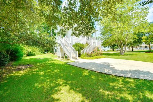 a house with stairs in a yard with trees at Less Than 6 Mi to Nags Head Manteo Beach House in Manteo