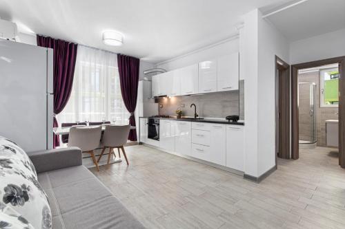 a kitchen and living room with a couch and a table at Maeve - Pool & Spa Beach Resort in Mamaia Nord